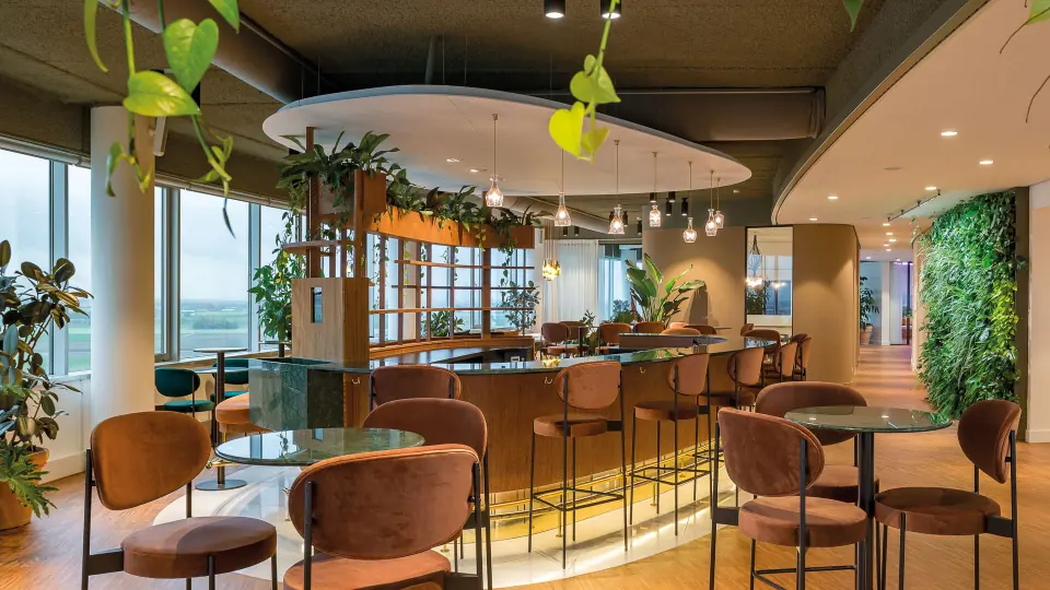 Ronde bar in Pharos met planten, hanglampen en terracotta stoelen